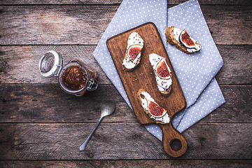 Image showing Bruschetta and Sliced figs on chopping board in rustic style