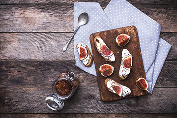 Image showing Bruschetta, jam and Sliced figs on chopping board in rustic styl