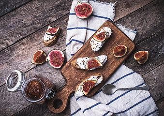 Image showing Bruschetta snacks with cut figs on napkin in rustic style