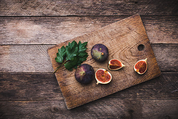 Image showing Tasty Figs on chopping board and wooden table