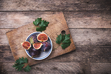 Image showing rustic style Cut figs in flat dish on choppingboard
