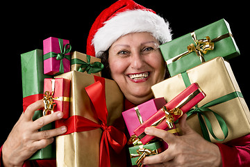 Image showing Cheerful Aged Woman Embracing Wrapped Presents 
