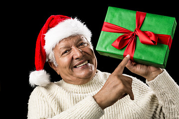 Image showing Old Man With Gentle Smile Pointing At Green Gift