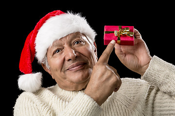 Image showing Male Senior With Red Pompom Hat And Christmas Gift