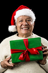 Image showing Male Senior With Santa Claus Cap and Green Gift