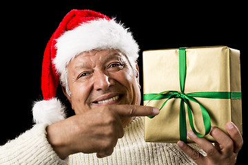 Image showing Broadly Grinning Aged Male Pointing At Golden Gift