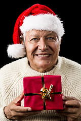 Image showing Aged Man With Santa Claus Cap and Red Xmas Gift