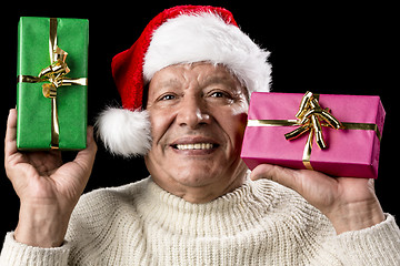 Image showing Kind Aged Gentleman With Red Cap Raising Two Gifts