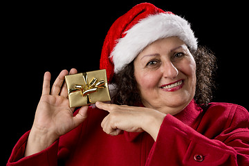 Image showing Happy Old Woman with Red Cap Points at Xmas Gift
