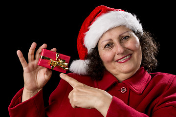 Image showing Joyful Aged Lady Pointing at Red Christmas Gift

