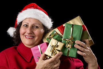 Image showing Mature Lady Holding Up Five Christmas Presents
