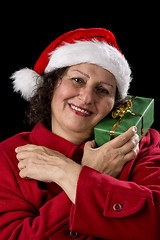 Image showing Happy Aged Woman with Santa Cap and Wrapped Gift
