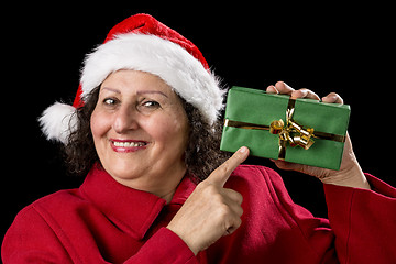 Image showing Smiling Mature Woman Pointing at Wrapped Xmas Gift
