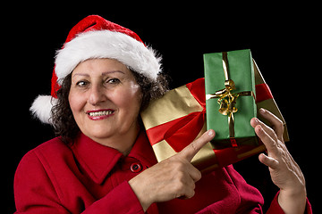 Image showing Senior Lady with Santa Cap Points at Wrapped Gifts
