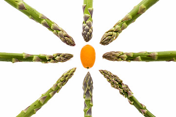 Image showing Eight Asparagus Spears Aiming at One Kumquat
