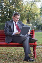 Image showing Businessman with laptop outside