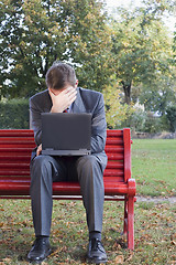 Image showing Tired businessman with laptop