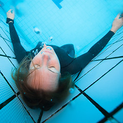 Image showing Female diver with eyes closed underwater in swimming pool