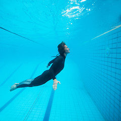 Image showing Female diver flying underwater