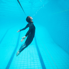 Image showing Female diver flying underwater