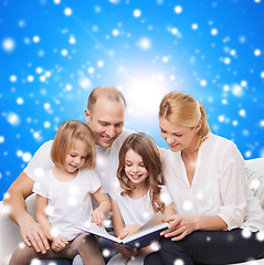 Image showing happy family with book at home