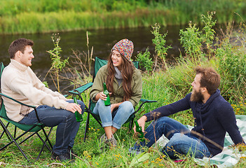 Image showing group of smiling tourists drinking beer in camping