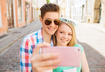 Image showing smiling couple with smartphone in city