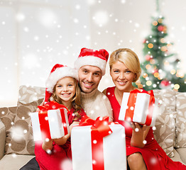 Image showing smiling family holding many gift boxes