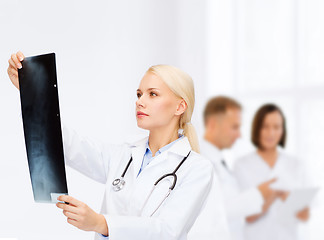 Image showing serious female doctor looking at x-ray