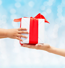 Image showing close up of child and mother hands with gift box