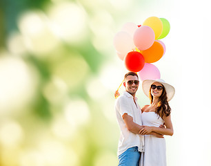 Image showing smiling couple with air balloons outdoors