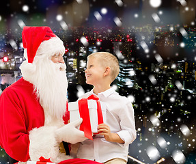 Image showing smiling little boy with santa claus and gifts