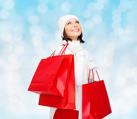 Image showing smiling young woman with red shopping bags