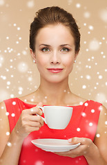 Image showing smiling woman in red dress with cup of coffee