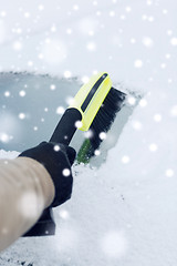 Image showing closeup of man cleaning snow from car