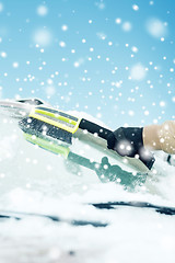 Image showing closeup of man cleaning snow from car