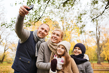 Image showing happy family with camera in autumn park