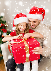 Image showing smiling father and daughter with gift box at home