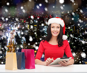 Image showing smiling woman with shopping bags and tablet pc