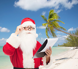 Image showing man in costume of santa claus with notepad