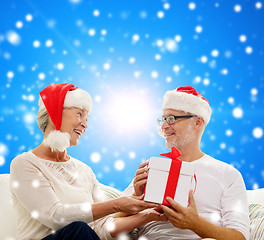 Image showing happy senior couple with gift box at home