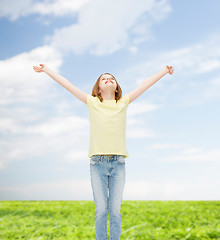 Image showing smiling teenage girl with raised hands