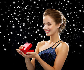 Image showing smiling woman holding red gift box