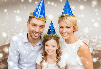 Image showing smiling family in party hats at home