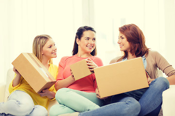 Image showing smiling teenage girls with cardboard boxes at home