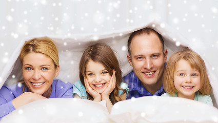 Image showing happy family with two kids under blanket at home