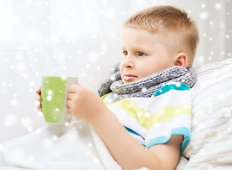 Image showing ill boy with flu in bed drinking from cup at home