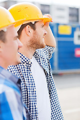 Image showing group of smiling builders in hardhats outdoors