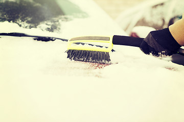 Image showing closeup of man cleaning snow from car