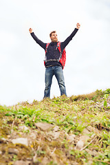 Image showing tourist with beard and backpack raising hands